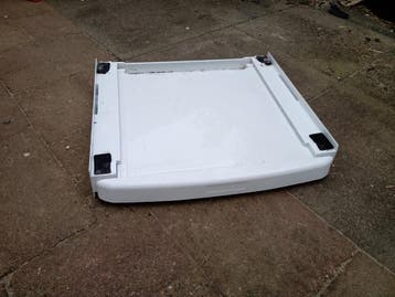 Uittrekbare steun voor wasmand tussen wasmachine en droger