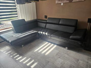 Zwarte hoekbank met lichte gebruikssporen