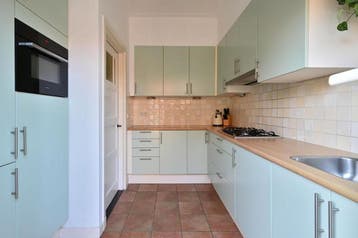 Keuken met koelvriescombinate en gasfornuis