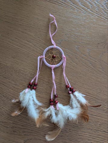 Gratis dromenvanger met roze details en veren