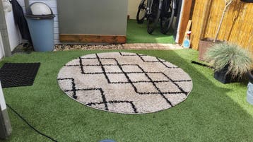 Een rond tapijt met een zwart patroon Gratis !