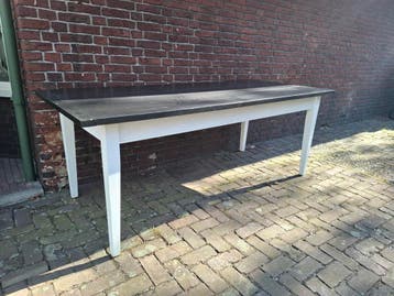 Robuuste houten tafel met zwart blad en witte poten