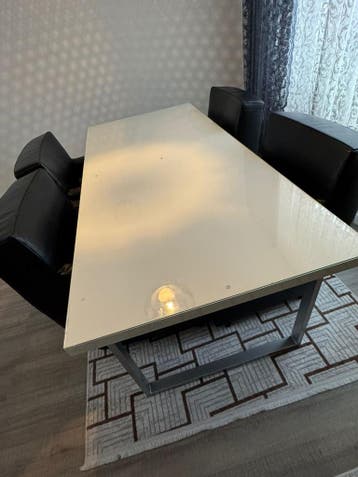 Een bed met een matras, een eettafel met stoelen