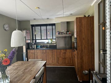 Moderne hoekkeuken met houtlook en inbouwapparatuur