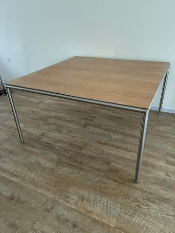 Tafel met houten blad en een onderframe van geborsteld staal