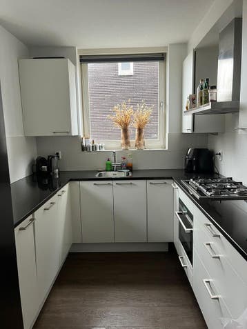 Moderne witte hoekkeuken met zwart werkblad gratis afhalen