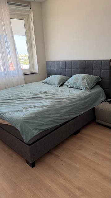 Comfortabel tweepersoonsbed met gestoffeerd hoofdbord