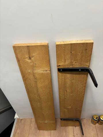 Houten muurplanken met zwarte ophangbeugels