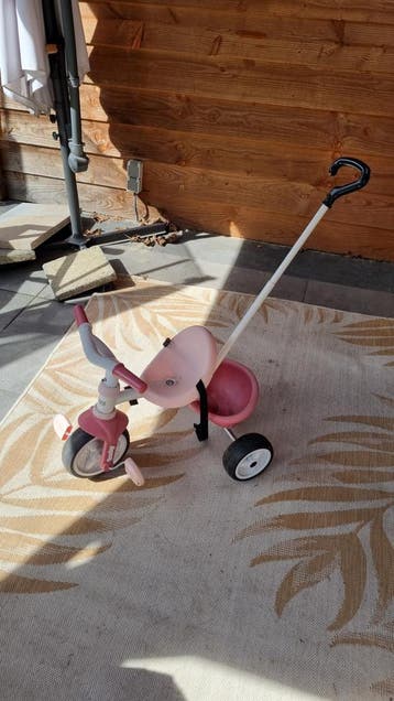 Roze driewieler met duwstang