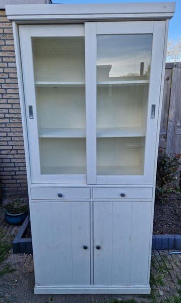 Witte vitrinekast met schuifdeuren en lades