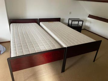 Twee eenpersoonsbedden met matrassen