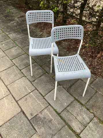 2 grijze kunststof stoelen met metalen poten