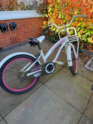 Witte kinderfiets met roze accenten en voordrager