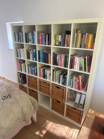 Grote witte boekenkast met opbergmanden