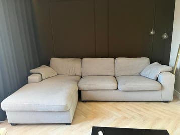 Bank met longchair lichtgrijze stof met gebruikssporen