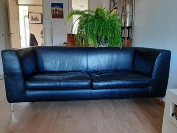 Zwarte leren tweezitsbank met lichte kattenkrabben