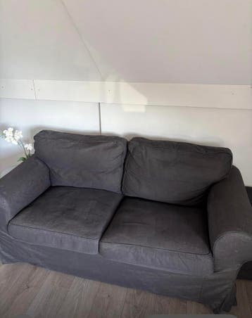 Comfortabele donkergrijze tweezitsbank ikea + opbergpoef