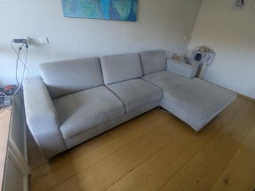 Grijze bank met chaisse lounge en opbergruimte (Leen Bakker)