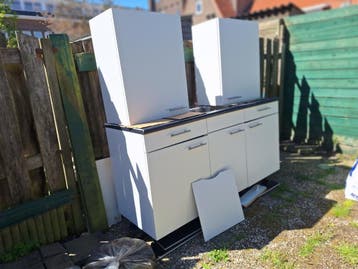 Compacte witte keuken met bovenkasten en spoelbak
