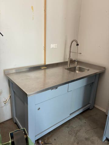 RVS tafel met spoelbak en keuken kast met 2 ovens en koelkas