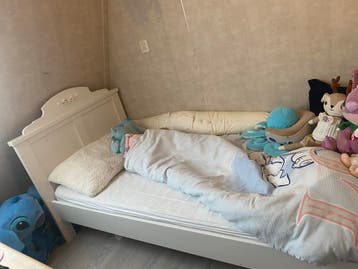Eenpersoonsbed wit met sierlijke hoofdbord