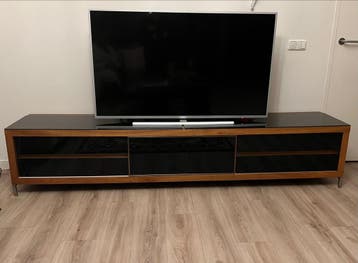 Grratis Modern TV-meubel met glazen blad en schuifdeuren.