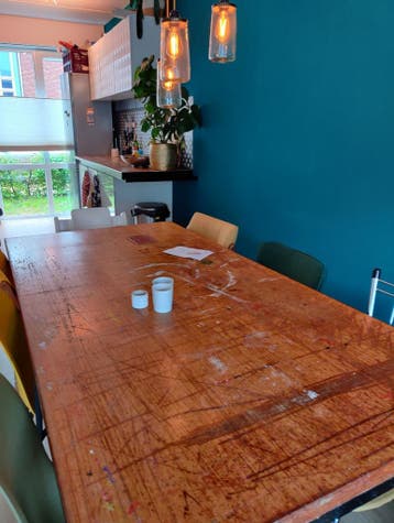 Grote houten eettafel met metalen onderstel