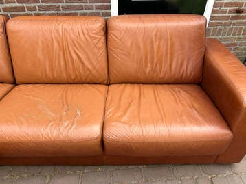 Leren hoekbank met chaise longue en losse hocker