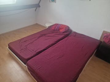 Twee eenpersoonsbedden met lattenbodems en nachtkastjes