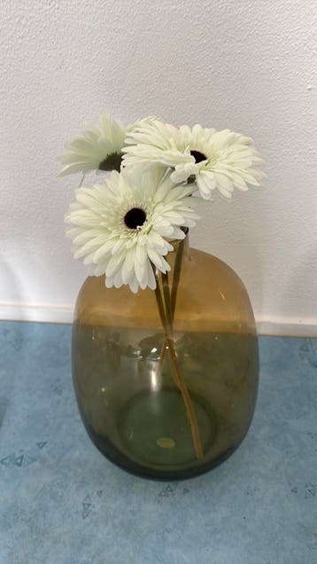Gratis: groene vaas met drie kunstgerberas
