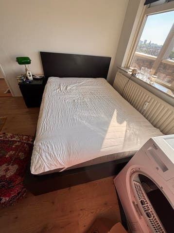 Tweepersoonsbed met hoofdbord en nachtkastje