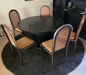 Ronde zwarte tafel met 5 stoelen.