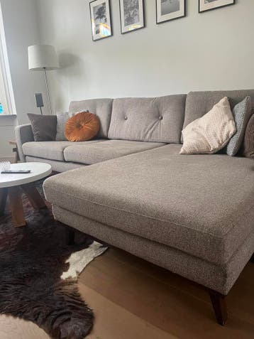 Comfortabele grijze stoffen bank met houten poten