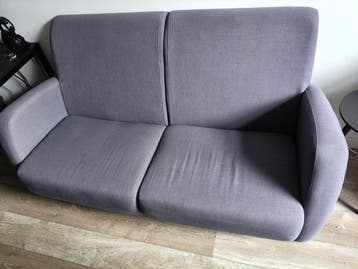 Grijze tweepersoons bank zit lekker comfortabel