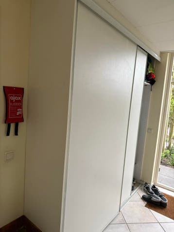 Witte inbouwkast met schuifdeuren en veel opbergruimte