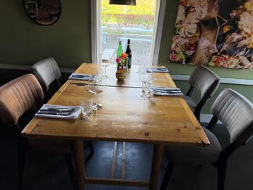 Houten brocante eettafel en 6 zwarte stoelem