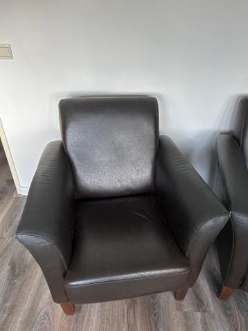 Twee comfortabele donkerbruine leren fauteuils