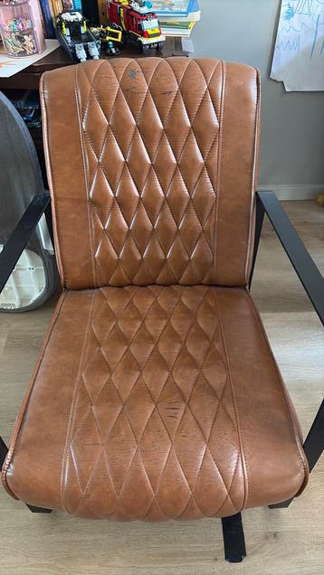 Leren fauteuil met kapotte stof