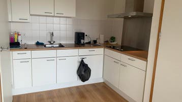 Gratis Moderne witte hoekkeuken met houten blad en afzuigkap