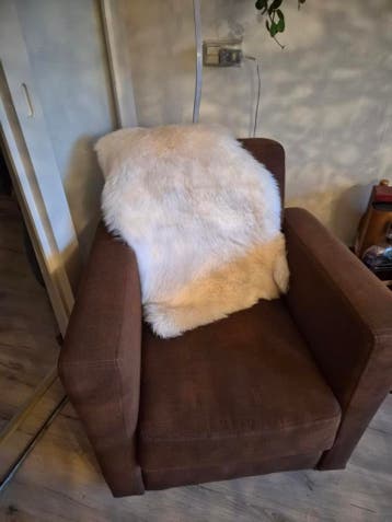 Comfortabele bruine fauteuil met schapenvacht