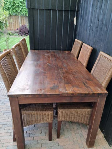 Robuuste houten tuintafel met 6 wicker stoelen