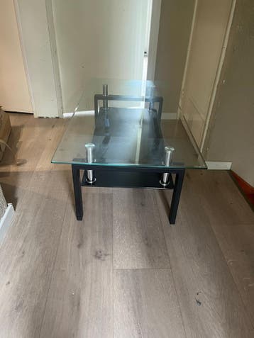 Moderne glazen salontafel met zwart onderstel