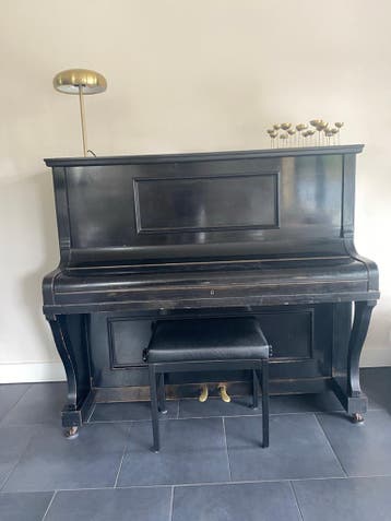 Zwarte piano met krukje