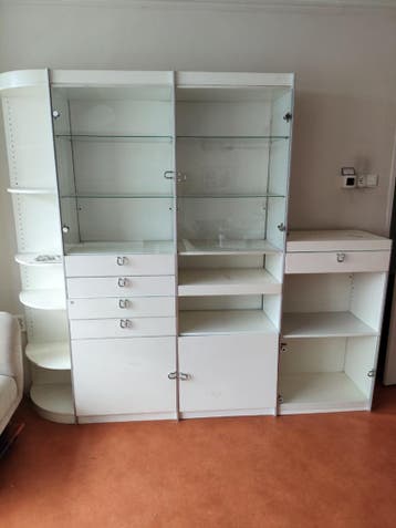 Witte kastenwand met vitrinekasten en lades