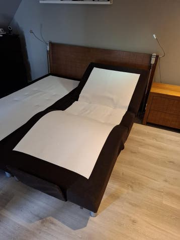 Verstelbaar tweepersoonsbed met houten hoofdbord