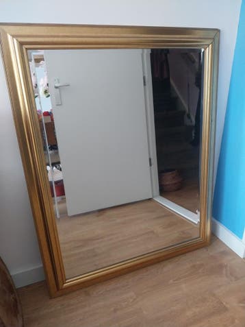 Grote gouden spiegel met sierlijke lijst