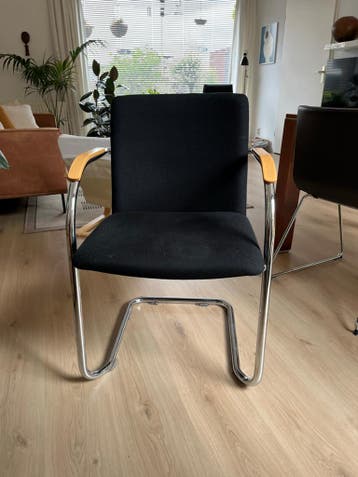 Zwarte stoel met chromen frame en houten armleuningen