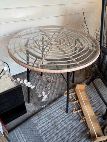 Ronde tafel met glazen blad op rotan bovenblad.