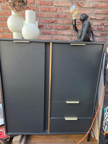 Mat zwarte kast met gouden accenten en 2 lades