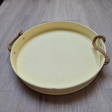 Ronde decoratieve metalen dienblad met handvatten van touw.